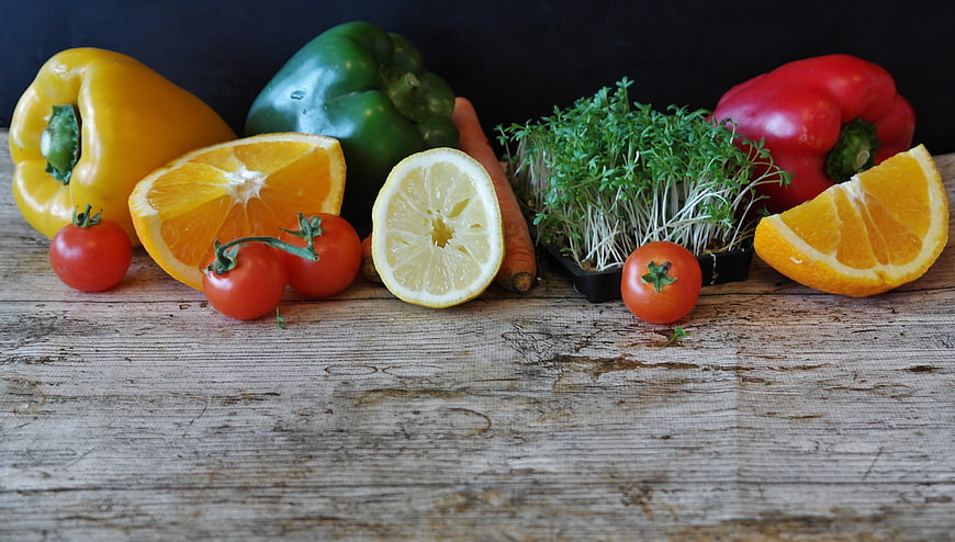 Fresh vegetables and citrus fruits on rustic wooden table