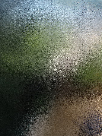 Frosted Glass Texture with Raindrops and Blurred Green Background
