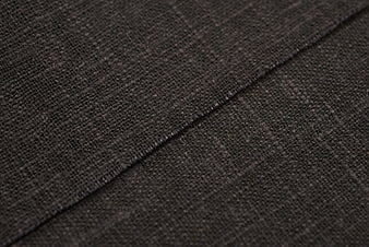 Close-up of dark gray woven fabric texture with stitching detail