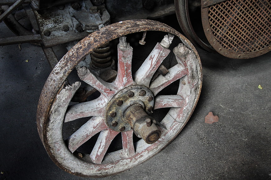 Rusty vintage wooden spoke wheel with peeling paint