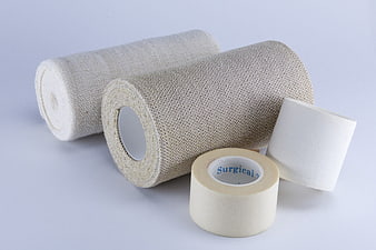 Medical bandages and surgical tape rolls on white background