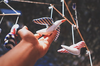 Hand touching striped bird mobile toy