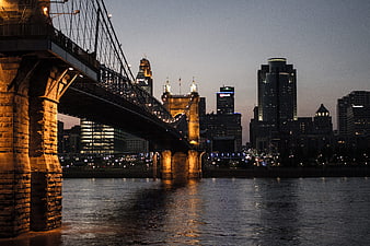 Rochester NY skyline at dusk with suspension bridge over river