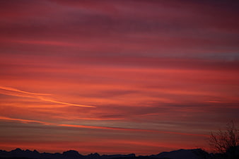 Vibrant Red and Orange Sunset Sky Over Mountain Silhouette