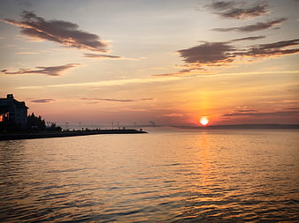 Golden Sunset Over Calm Sea With Silhouette Pier