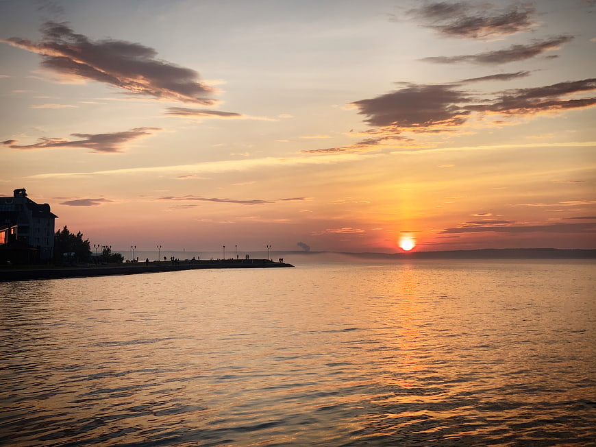 Golden Sunset Over Calm Sea With Silhouette Pier
