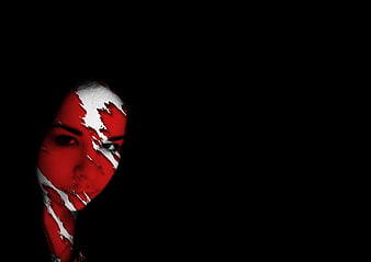 Woman with red and white face paint in dark shadows