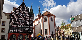 Historic Half-Timbered Building and Church in German Town Square