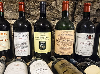 Collection of French Bordeaux wine bottles in stone cellar