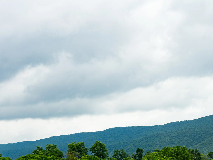 Cloudy Sky Over Green Mountain Range Landscape