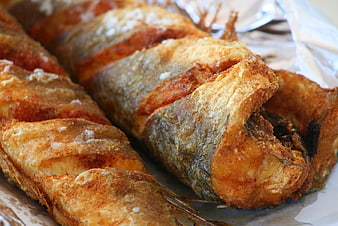Close-up of golden fried fish fillets on aluminum foil
