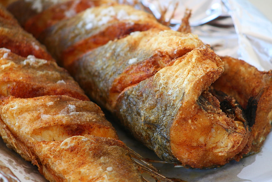 Close-up of golden fried fish fillets on aluminum foil