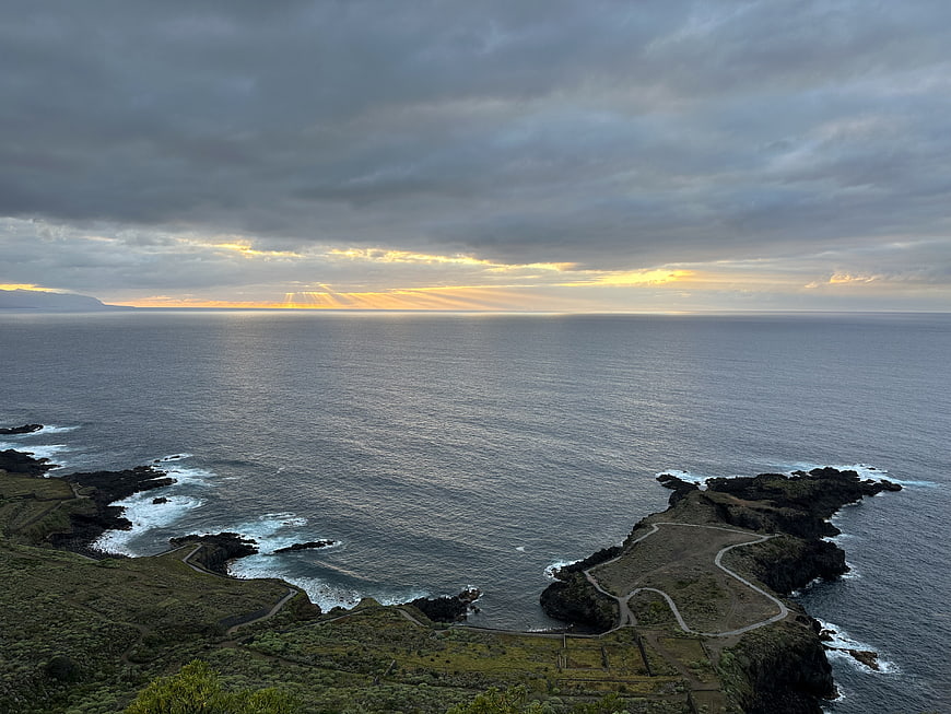 Dramatic coastal landscape with sun rays breaking through clouds