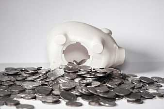 White Piggy Bank Spilling Silver Coins on White Background