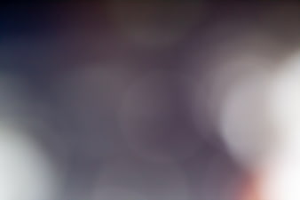 Abstract purple and white bokeh background with soft glowing lights