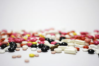 Assorted colorful pills and capsules on white background