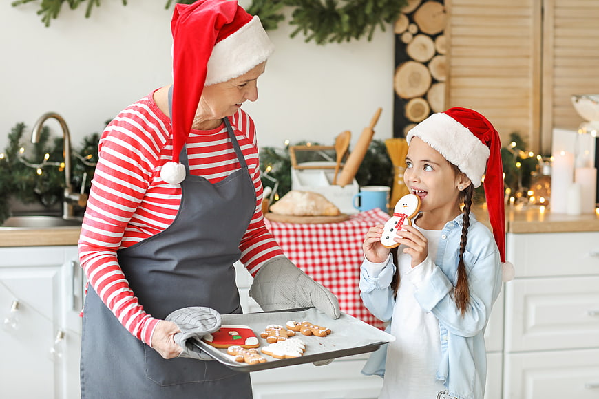 Grandmother and granddaughter baking Christmas cookies in kitchen