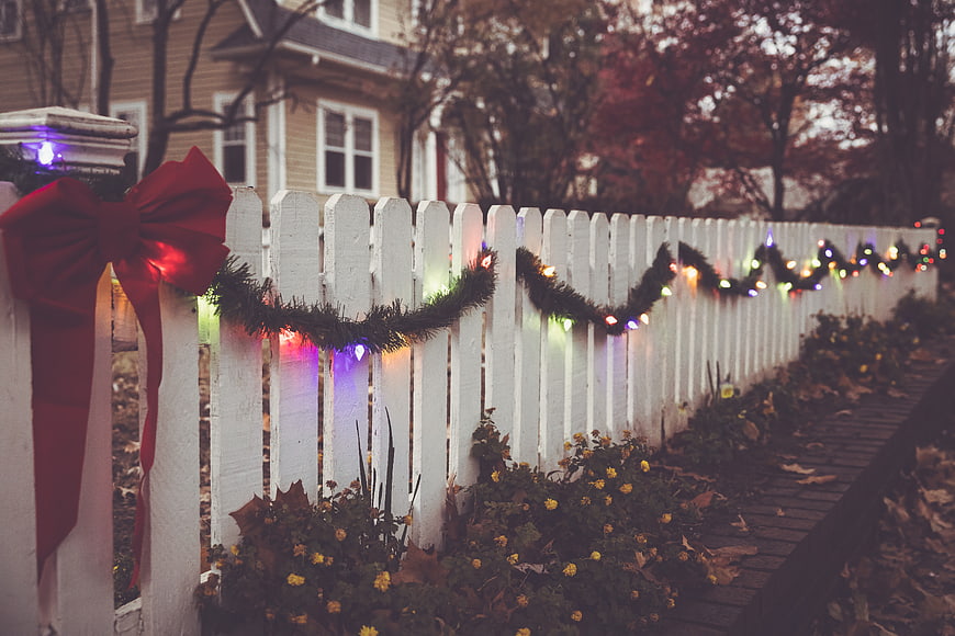 White Picket Fence with Christmas Lights and Red Bow