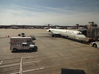 Delta Airlines plane parked at airport gate with ground crew