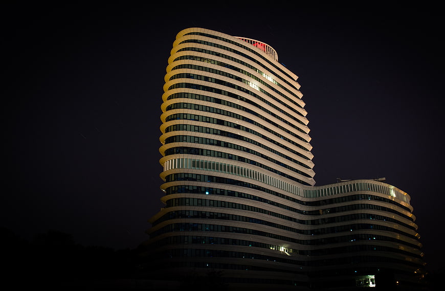 Modern Curved Office Building Illuminated at Night