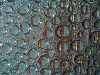 Macro water droplets on glass with blue and brown reflections