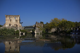 Medieval Castle Ruins Reflected in Calm River Water