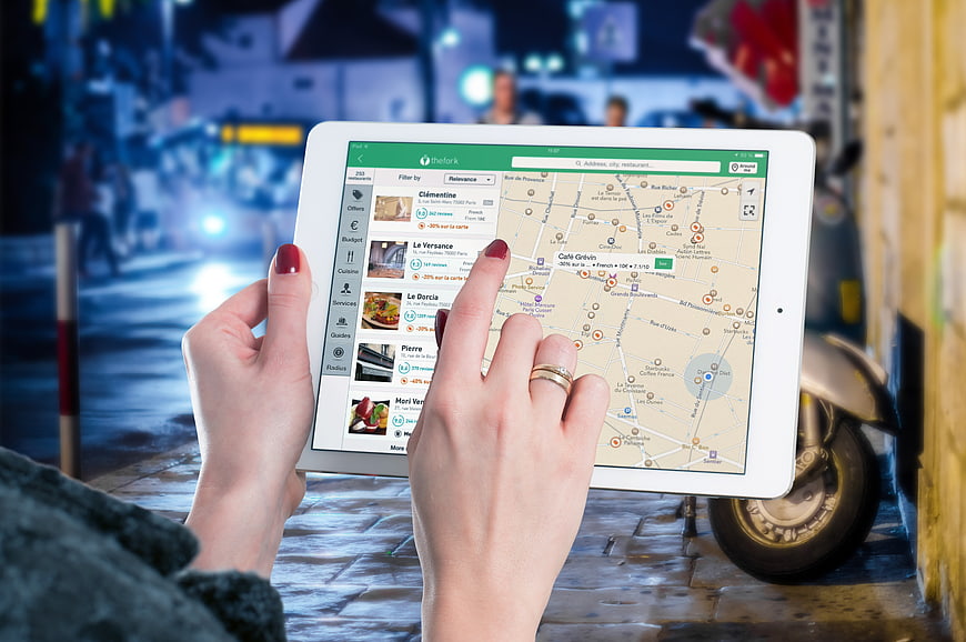 Woman using restaurant app on tablet at night