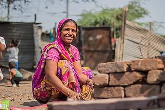 Smiling Indian woman in colorful sari working outdoors