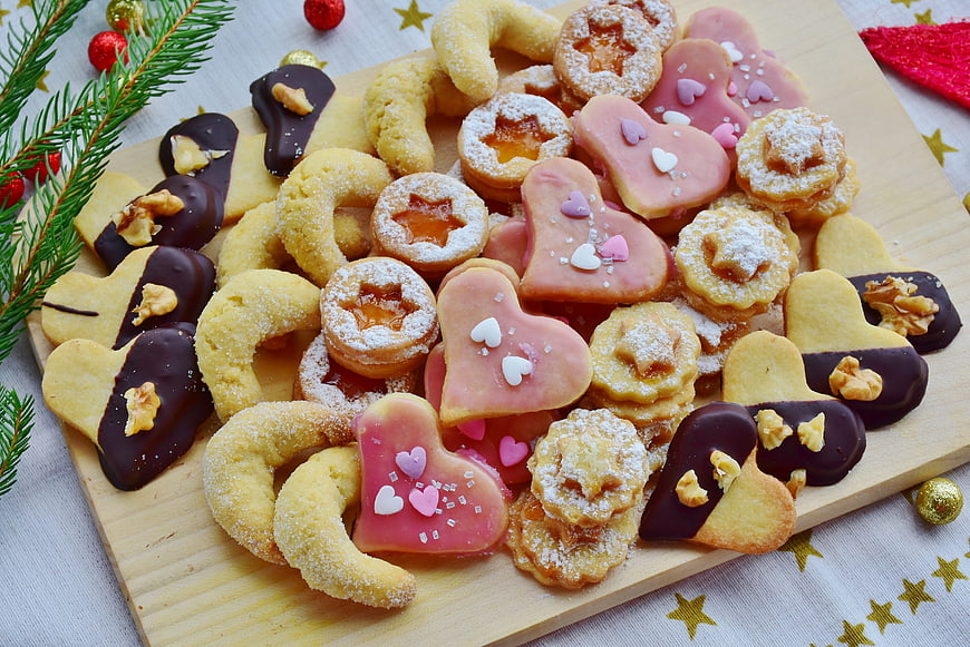 Assorted Christmas Cookies on Wooden Board with Pine Sprigs