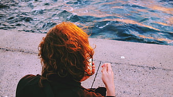 Woman with Red Hair Taking Photo of Ocean Sunset