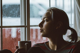Contemplative Woman Looking Out Window with Coffee