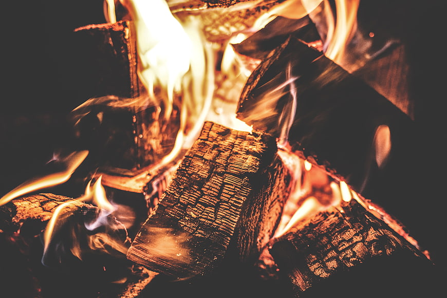 Close-up of burning firewood logs with bright orange flames