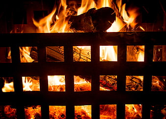 Close-up of burning logs in a metal fire pit