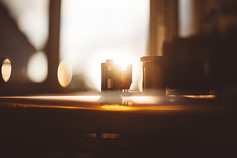 Batteries on wooden surface with warm sunlight and lens flare