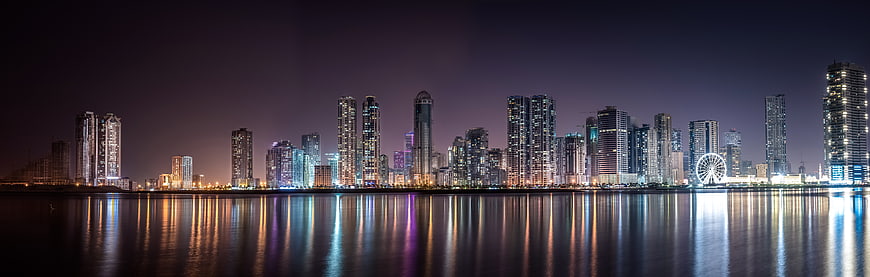 Panoramic Night Skyline of Modern City with Water Reflections