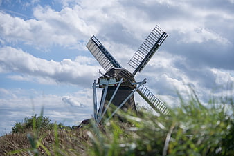 Traditional Dutch Windmill Against Cloudy Blue Sky