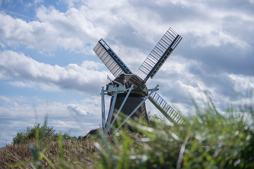 Traditional Dutch Windmill Against Cloudy Blue Sky