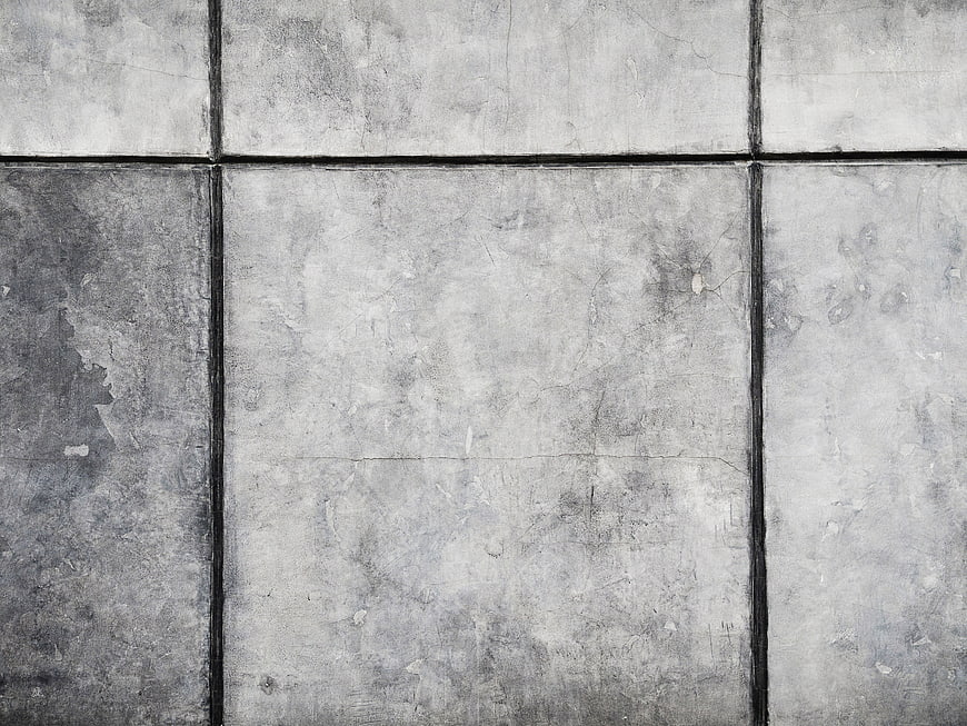 Textured gray concrete wall tiles with dark grout lines