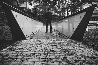 Man Walking on Modern Bridge in Autumn Leaves Black and White