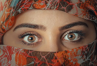 Close-up portrait of woman's eyes with patterned hijab