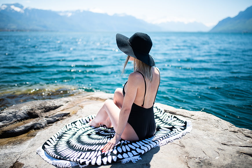 Woman in Black Swimsuit Sitting on Lake Shore