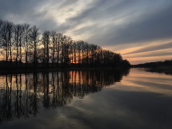 Serene Sunset Reflection on River with Silhouetted Trees