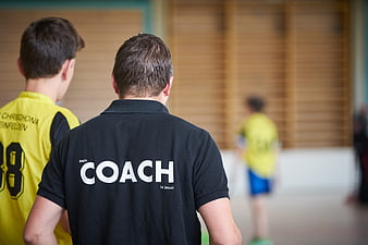 Coach with religious message on shirt in gym
