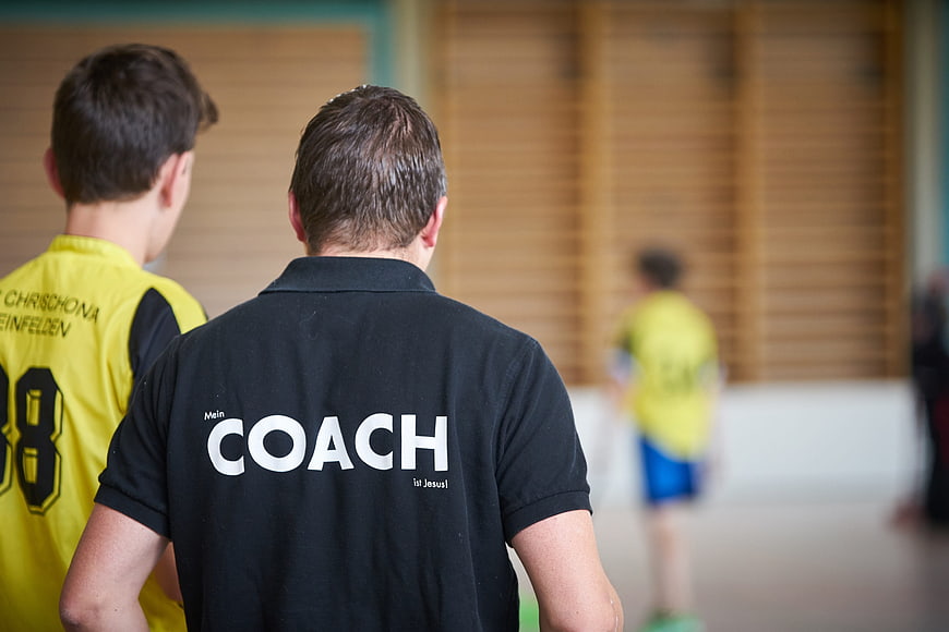 Coach with religious message on shirt in gym