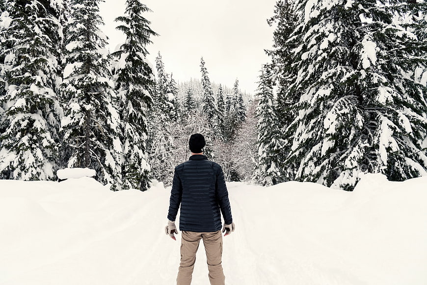 Man Walking Away in Snowy Forest Path