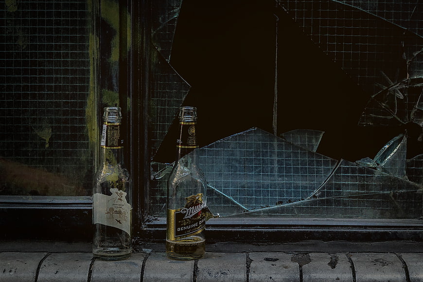 Broken Beer Bottles on Windowsill with Shattered Glass