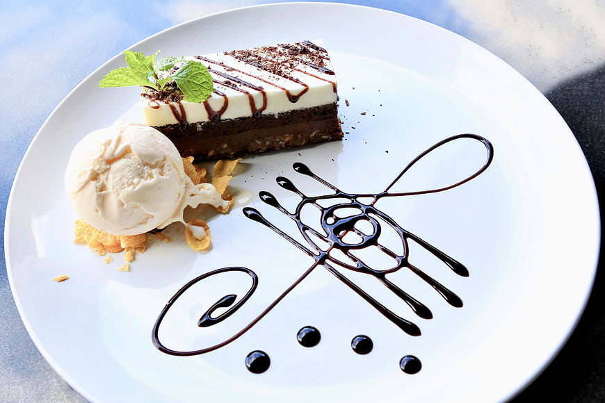 Chocolate brownie slice with vanilla ice cream and chocolate sauce art