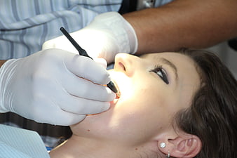 Dentist examining patient teeth with dental tool
