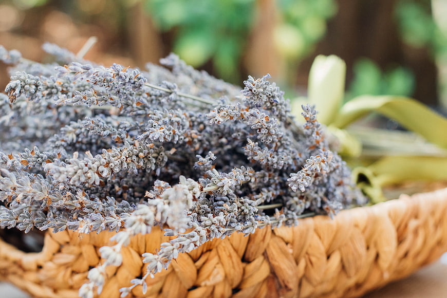 Dried lavender bouquet in woven basket with green ribbon