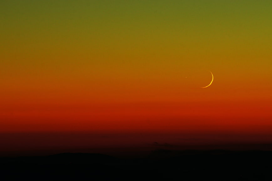 Crescent Moon in Vibrant Orange and Green Gradient Sky